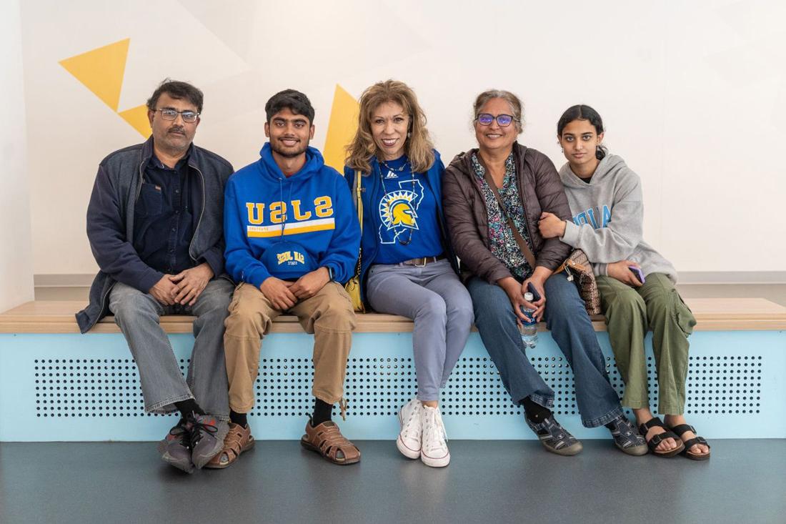 The president posing with a student and their family.