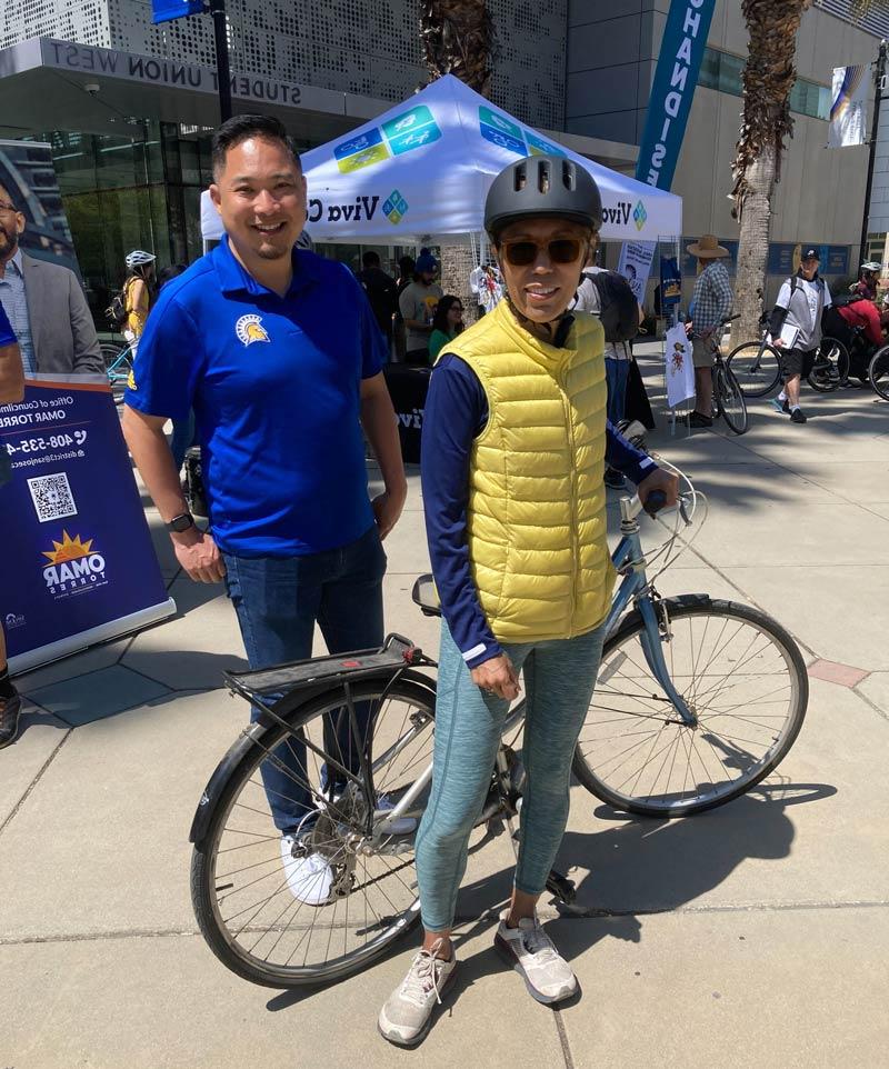 The president posing with her bike and a staff member at Viva Calle.