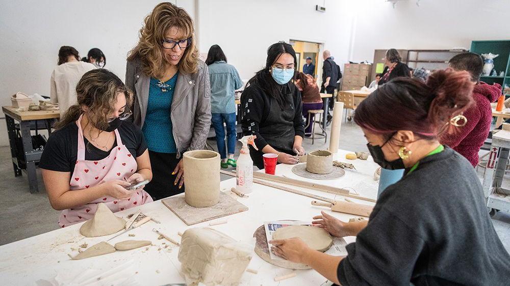 The president look at student art.