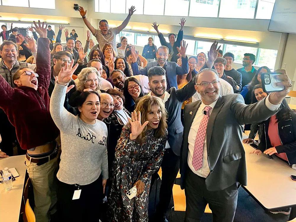 The president taking a selfie with the division of research and innovation.